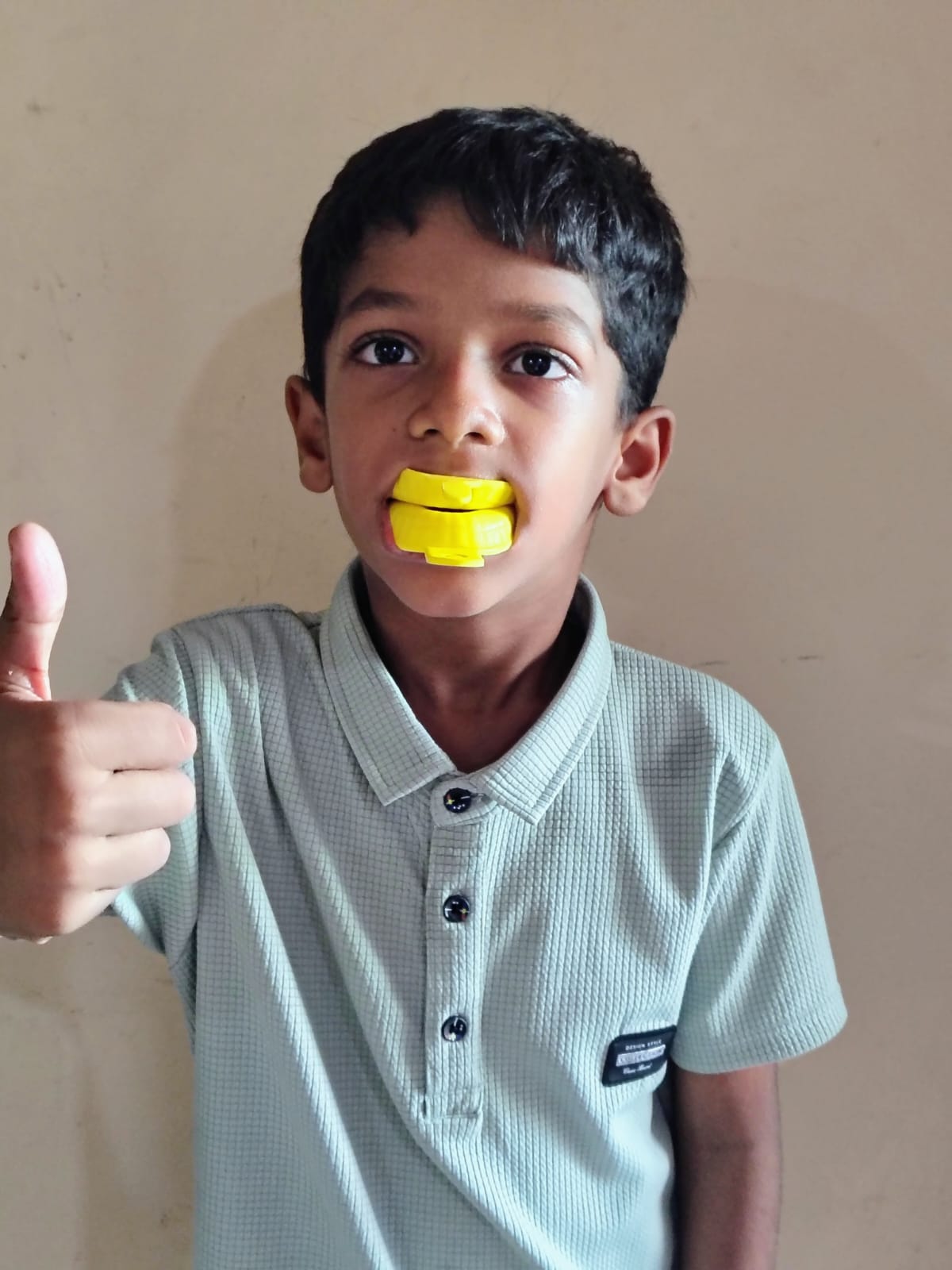 Boy with a fluoride tray giving a thumbs up